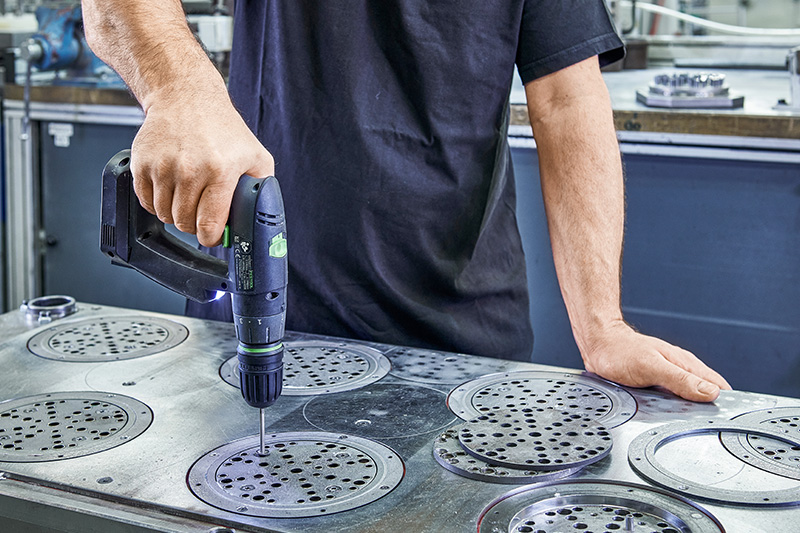 Työntekijä työstää metallilaikkoja