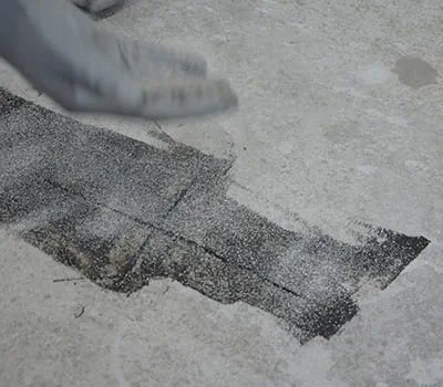 Kvartsihiekan ripotteleminen vielä tuoreeseen valuhartsiin.