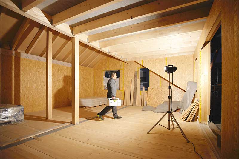 Rakennustyövalaisin valaisee ikkunattoman, pimeän huoneen -