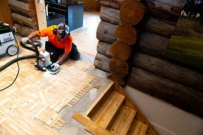 Suomalainen parkettiasentaja työstää lattiaa Festool-yläjyrsimellä